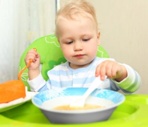 Cute little child eating blended carrot