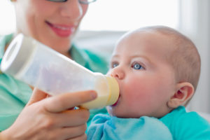 Cute baby brinking from a bottle